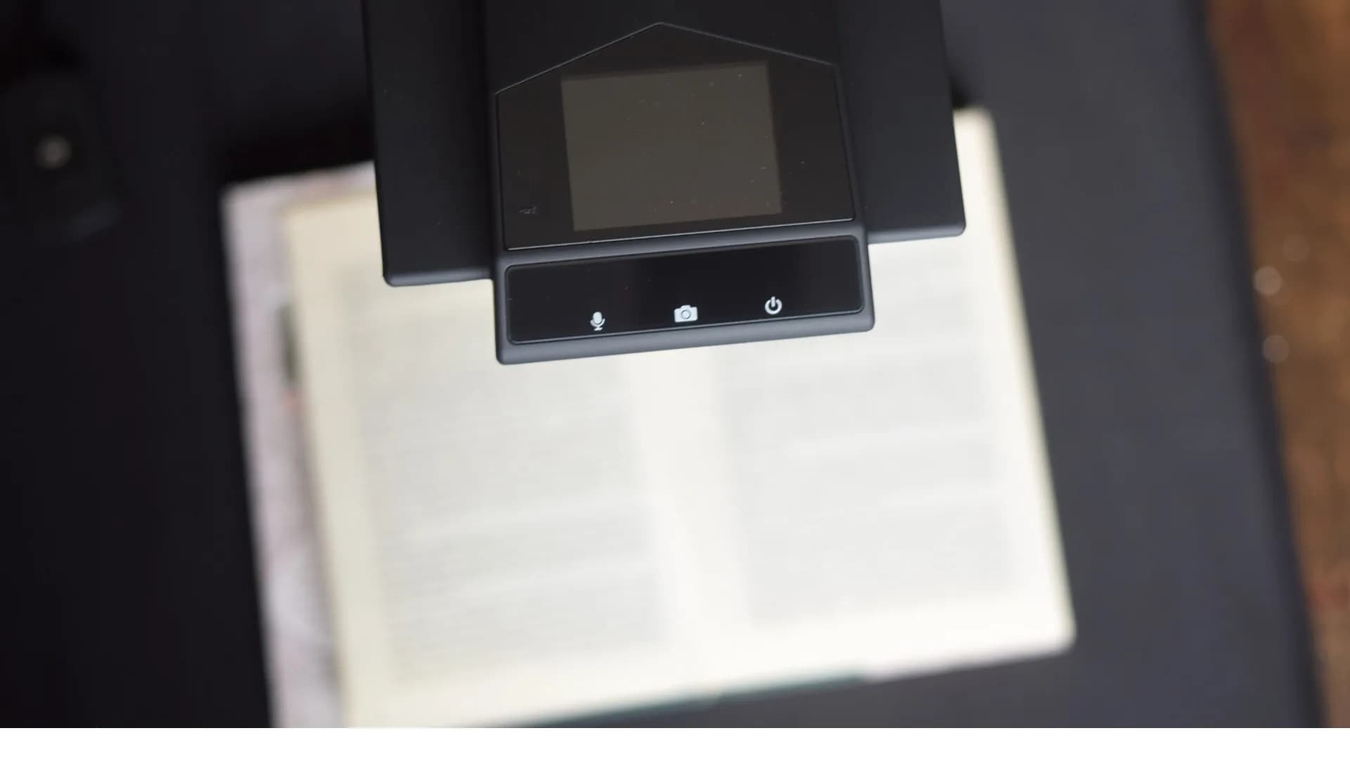Vista cenital del cabezal del escáner con sus controles sobre un libro abierto